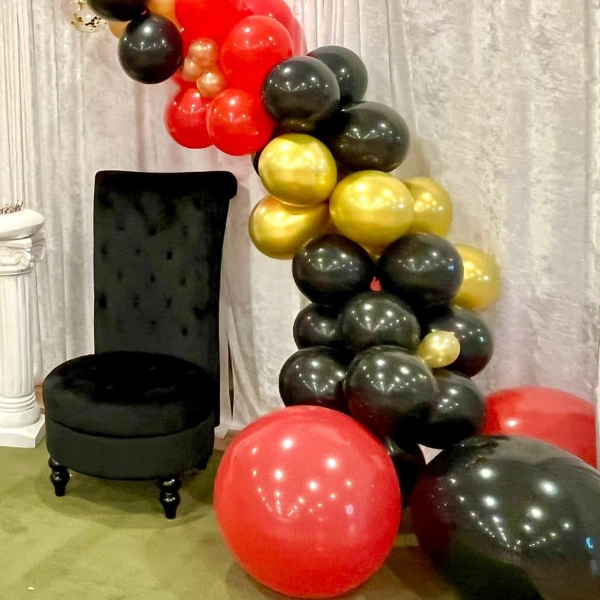 Beautiful red gold black balloon arch and black party throne